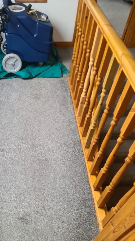 The carpet cleaning machine on a sheeted landing at the top of the stairs.